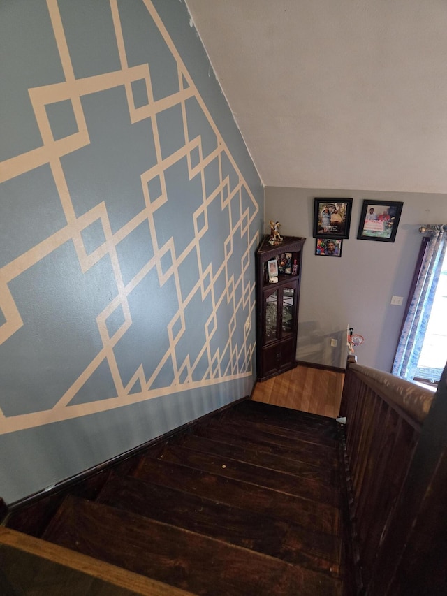 staircase with vaulted ceiling and wood finished floors