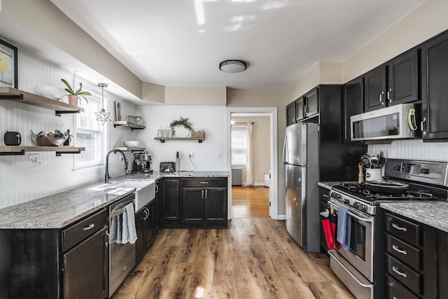 631 Main St, Tatamy, PA 18085 - kitchen featuring appliances with stainless steel finishes, open shelves, a sink, radiator heating unit, and light wood-style floors