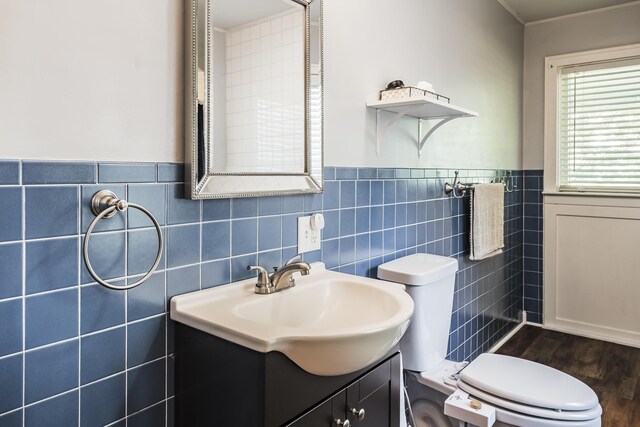 631 Main St, Tatamy, PA 18085 - bathroom featuring toilet, vanity, tile walls, wood finished floors, and a wainscoted wall