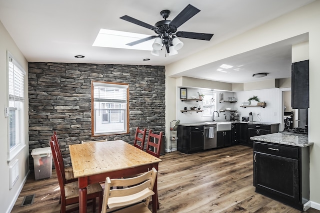 631 Main St, Tatamy, PA 18085 - kitchen with dark cabinets, open shelves, stainless steel dishwasher, a skylight, and wood finished floors