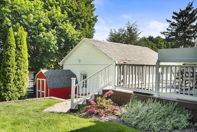 631 Main St, Tatamy, PA 18085 - back of property featuring a shingled roof, a wooden deck, and a lawn