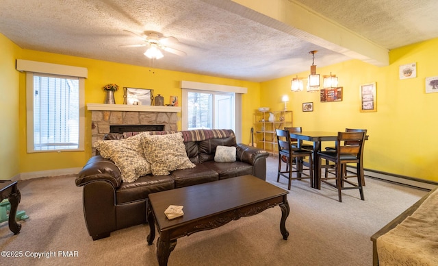 living area featuring a textured ceiling, a stone fireplace, carpet floors, baseboards, and baseboard heating