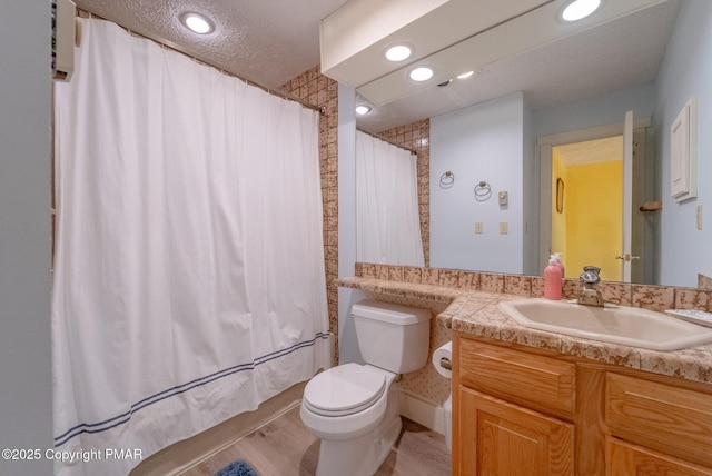 bathroom with toilet, recessed lighting, a textured ceiling, and vanity