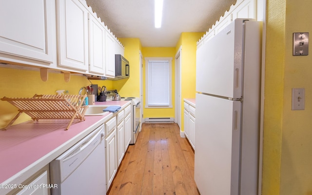 kitchen featuring a baseboard radiator, white appliances, a sink, white cabinetry, and light wood-type flooring