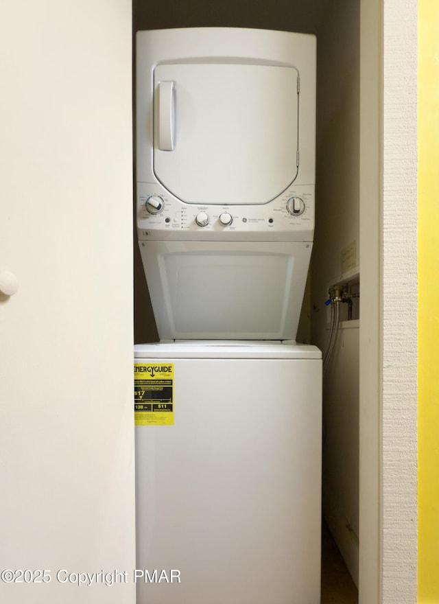 clothes washing area with stacked washer / dryer and laundry area