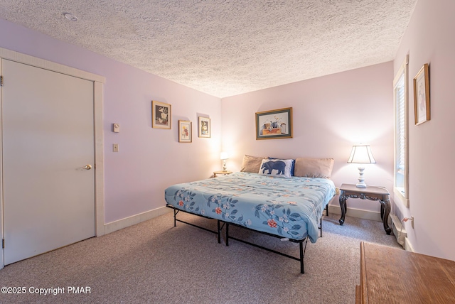 carpeted bedroom featuring a textured ceiling and baseboards