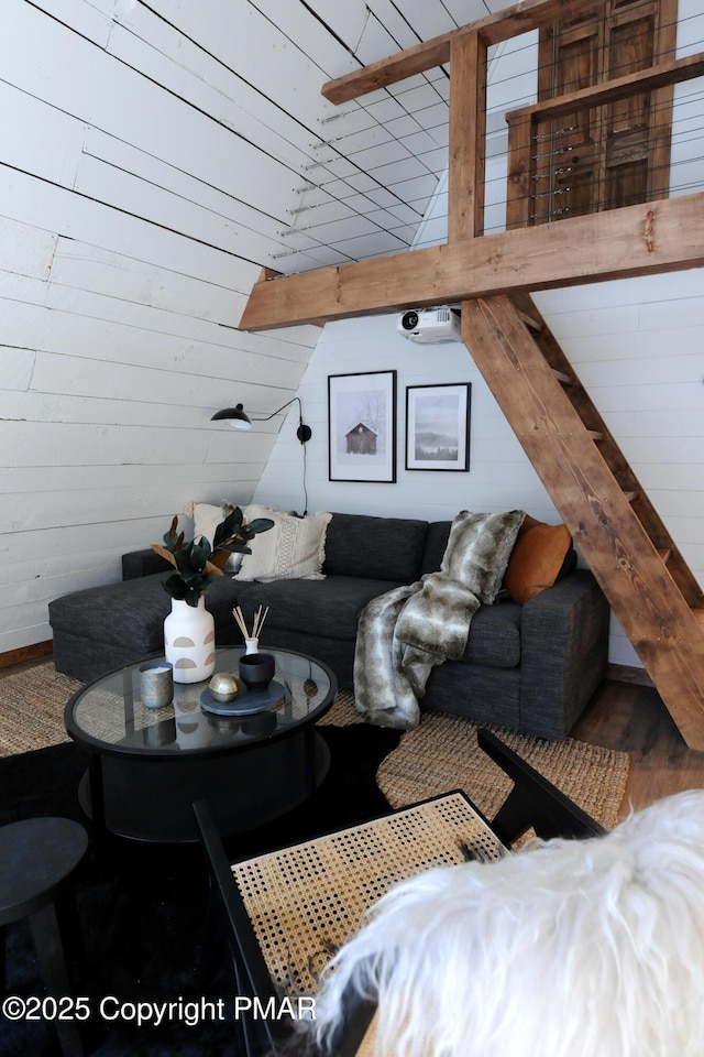 living room featuring lofted ceiling and wood walls