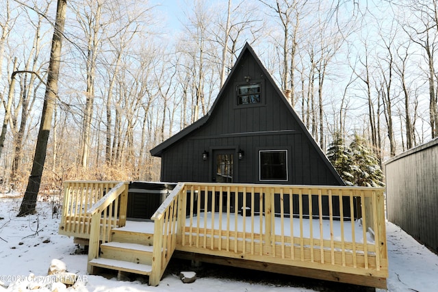 snow covered rear of property featuring a wooden deck