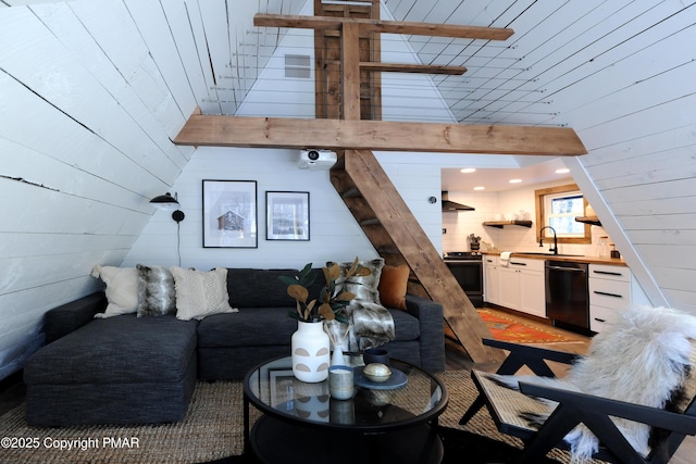 living room with sink, a towering ceiling, and wooden walls