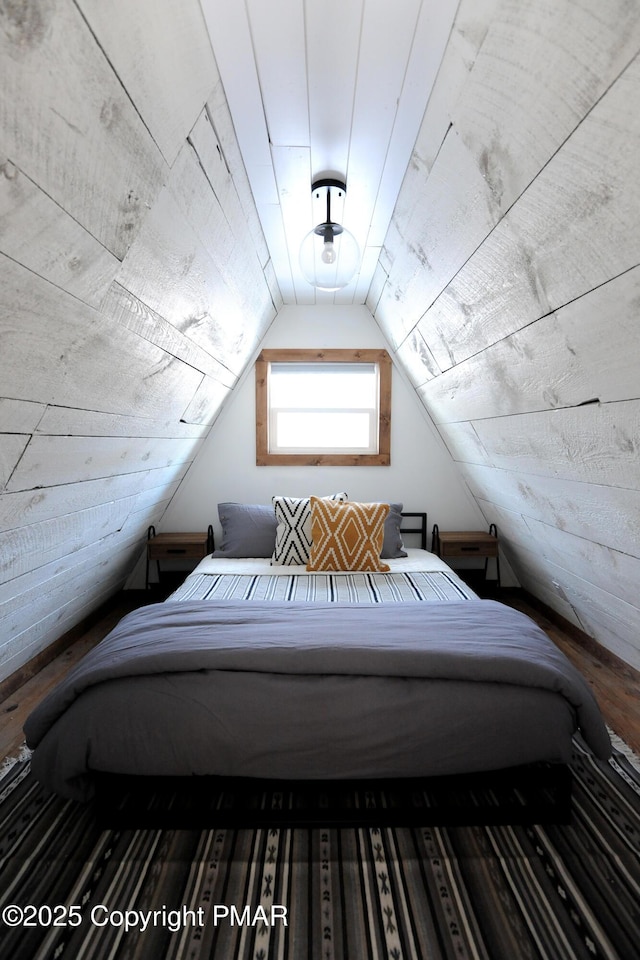 bedroom with vaulted ceiling and wooden walls