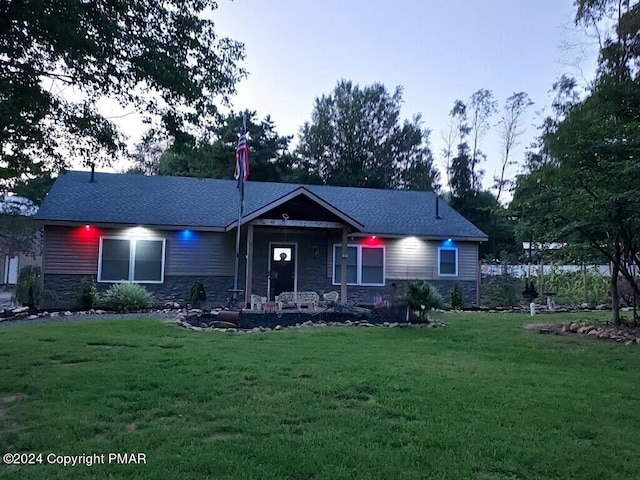 view of front of property with stone siding and a front lawn