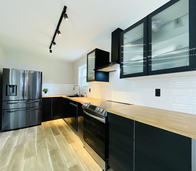 1216 Winding Way, Tobyhanna, PA 18466 - kitchen with stainless steel appliances, dark cabinets, custom exhaust hood, light wood-type flooring, and glass insert cabinets