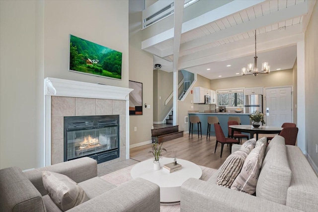 134 Laurel Hill Dr Unit 102, Greentown, PA 18426 - living room featuring beam ceiling, a fireplace, a chandelier, recessed lighting, and stairway