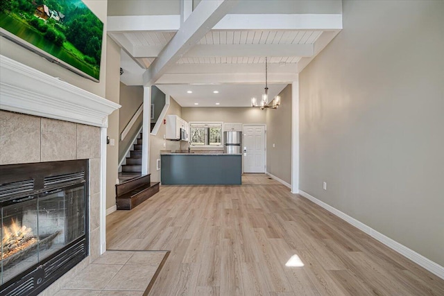 134 Laurel Hill Dr Unit 102, Greentown, PA 18426 - unfurnished living room featuring baseboards, a fireplace, light wood finished floors, and beam ceiling