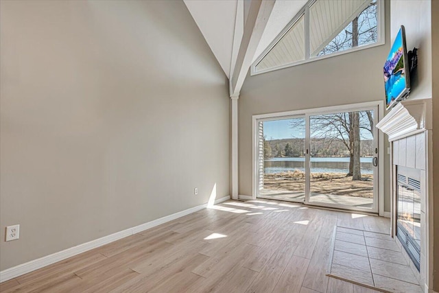 134 Laurel Hill Dr Unit 102, Greentown, PA 18426 - interior space with baseboards, a tiled fireplace, light wood finished floors, and high vaulted ceiling