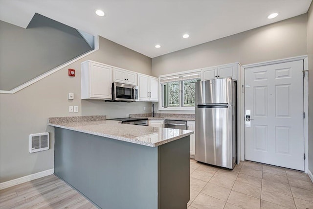134 Laurel Hill Dr Unit 102, Greentown, PA 18426 - kitchen with a peninsula, light stone countertops, baseboards, white cabinetry, and stainless steel appliances
