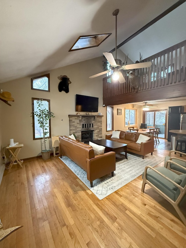 248 Penn Forest Trl, Albrightsville, PA 18210 - living room featuring ceiling fan, high vaulted ceiling, baseboards, wood-type flooring, and a glass covered fireplace