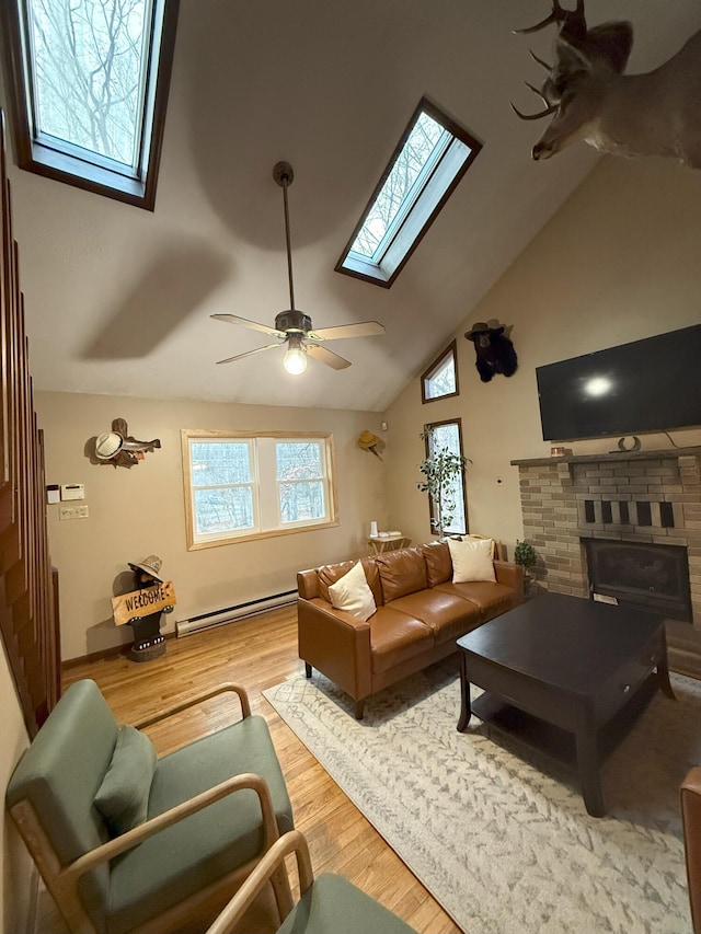 248 Penn Forest Trl, Albrightsville, PA 18210 - living area featuring a baseboard radiator, a skylight, a fireplace, wood finished floors, and a ceiling fan