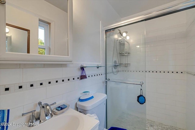 bathroom with a stall shower, a sink, toilet, and tile walls