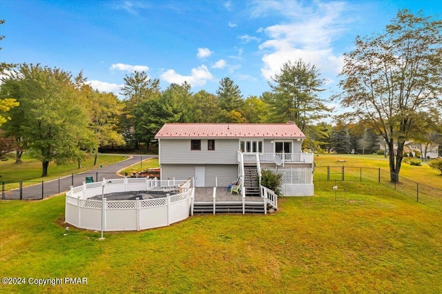 back of house featuring a deck, metal roof, a fenced backyard, a yard, and stairway