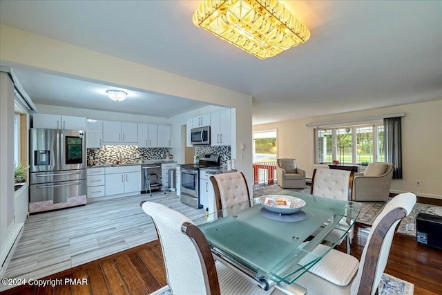 dining area with light wood-style flooring and baseboards