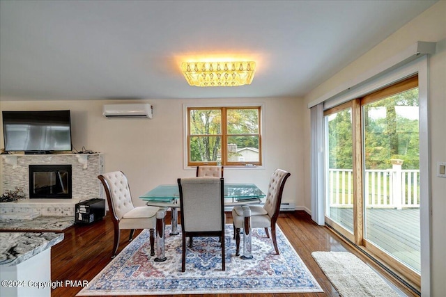 dining area with a glass covered fireplace, hardwood / wood-style flooring, and a wall mounted AC