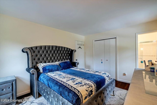 bedroom featuring a closet, baseboards, and wood finished floors