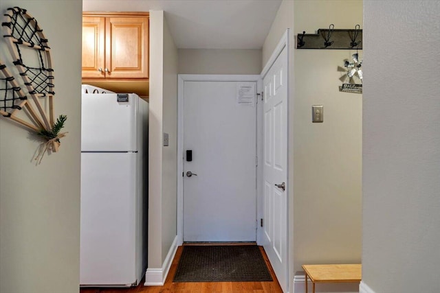 entryway with wood finished floors and baseboards