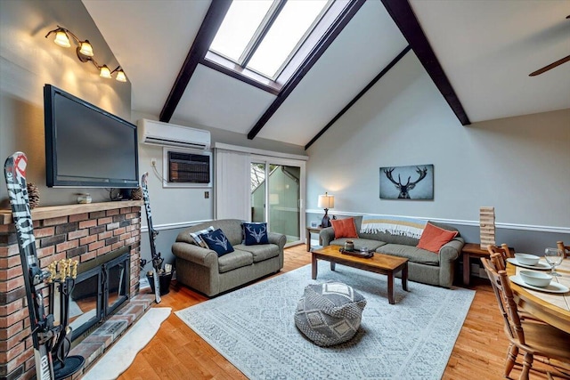 living area featuring a skylight, a wall unit AC, beamed ceiling, light wood-type flooring, and a brick fireplace