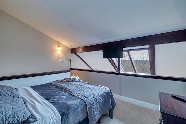 carpeted bedroom with lofted ceiling and baseboards