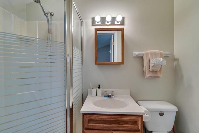 full bathroom featuring toilet, walk in shower, and vanity