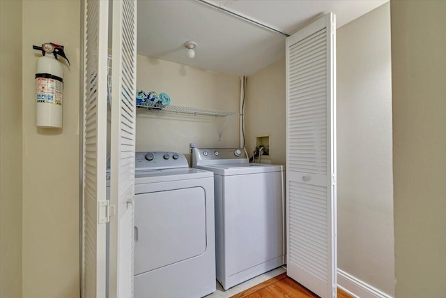 laundry area featuring light wood-type flooring, laundry area, and washing machine and clothes dryer