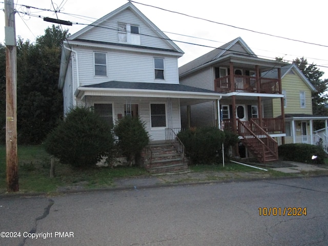 view of property featuring a porch and a balcony