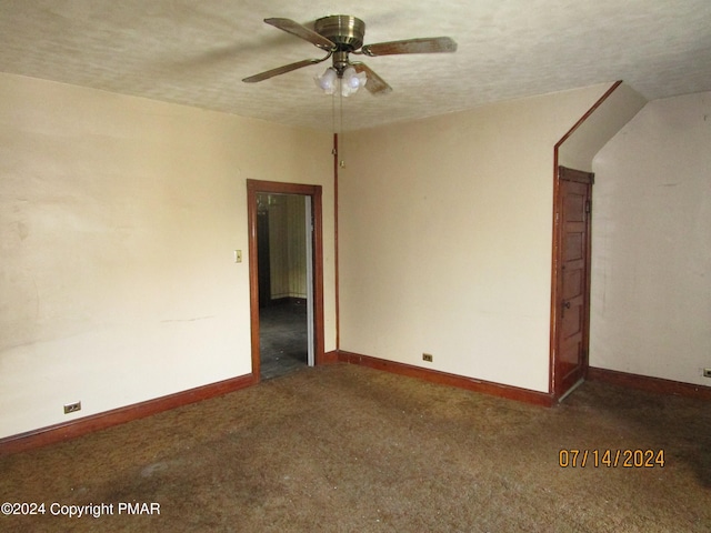 carpeted spare room featuring ceiling fan and a textured ceiling