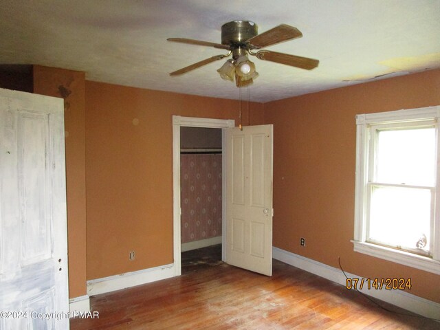 unfurnished bedroom with ceiling fan, a closet, and light wood-type flooring