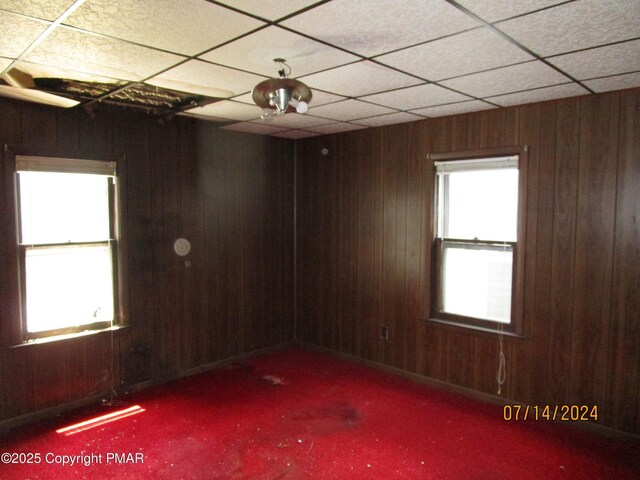 unfurnished room featuring wood walls