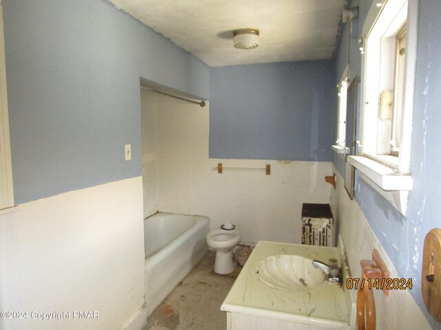 bathroom featuring a bidet, a tub to relax in, and vanity