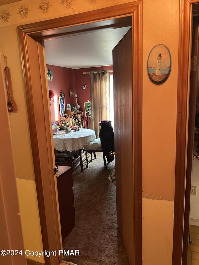 hallway featuring dark colored carpet