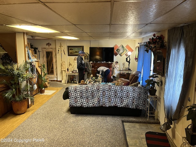 interior space with a paneled ceiling and wood finished floors