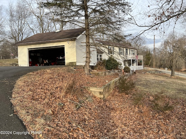 view of side of home with a garage and aphalt driveway