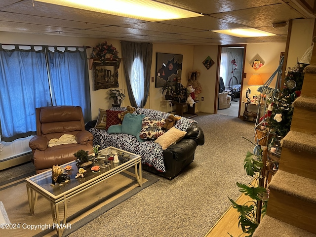 carpeted living room with a baseboard heating unit, stairway, and a drop ceiling