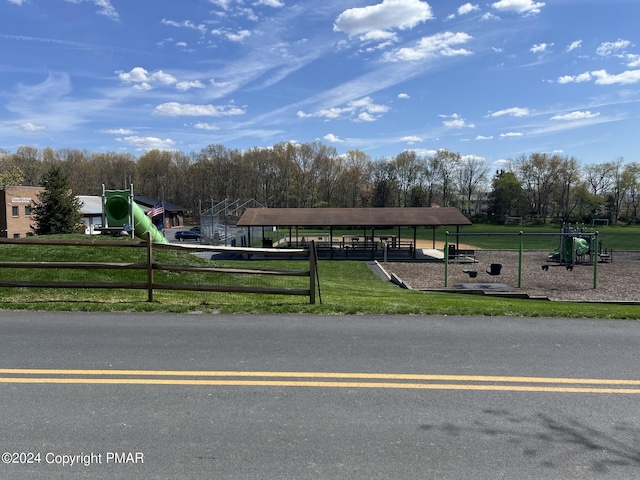 view of community with playground community, a yard, and fence