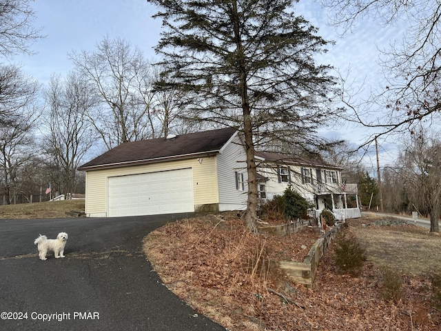 view of front facade with aphalt driveway and an attached garage