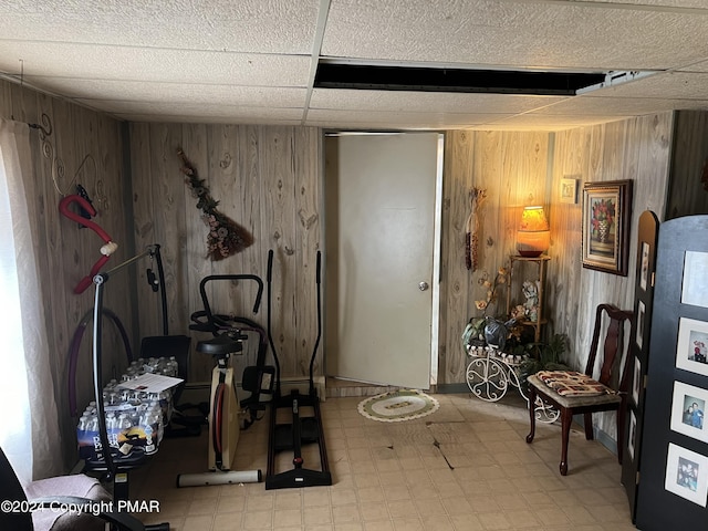 exercise room featuring wooden walls and light floors