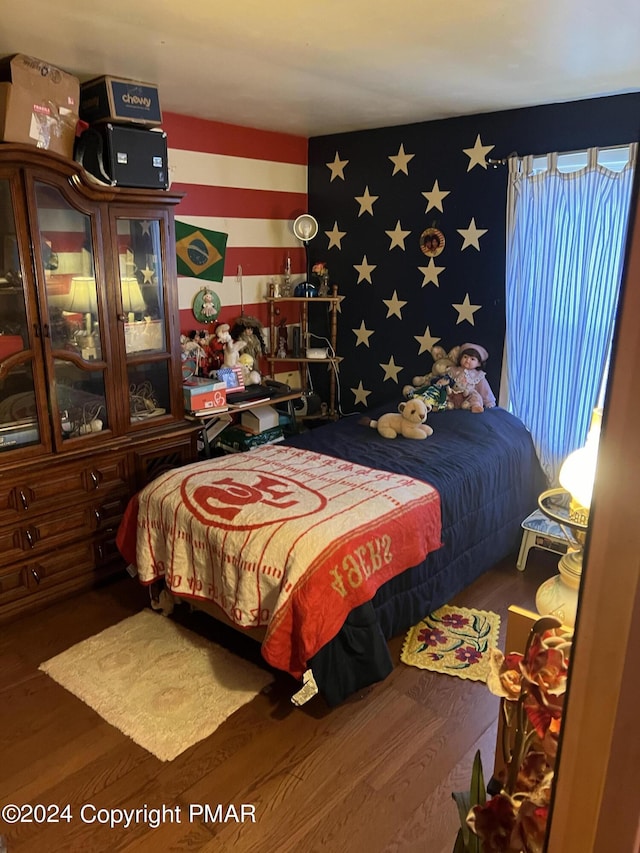 bedroom featuring wallpapered walls and wood finished floors