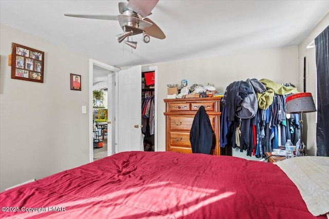 bedroom with a spacious closet and a ceiling fan