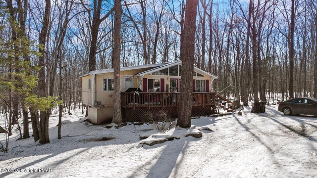 exterior space with a wooden deck and a sunroom