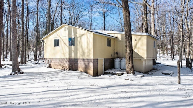 view of snowy exterior featuring an attached garage