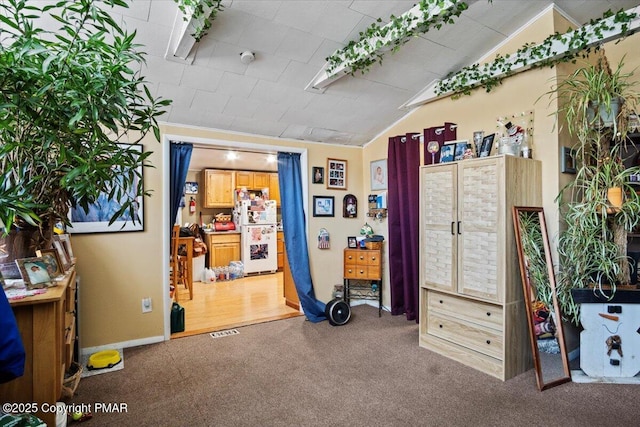 miscellaneous room featuring lofted ceiling, visible vents, and carpet flooring