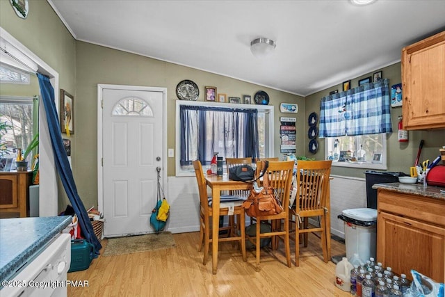 dining room with lofted ceiling, a wealth of natural light, and light wood-style floors